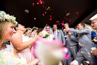 Photo of bride and groom being showered with pink rose petals by their guests as they exit the ceremony in Lancaster, PA