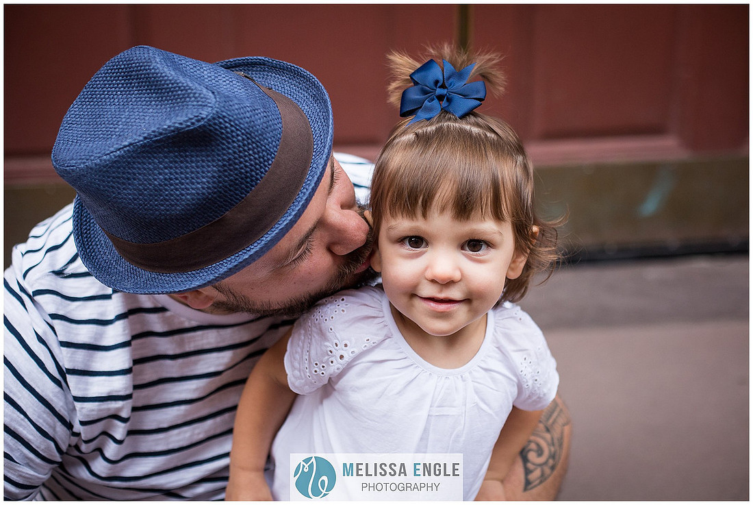Candid family photo of parents with twins in downtown Lancaster City, PA.