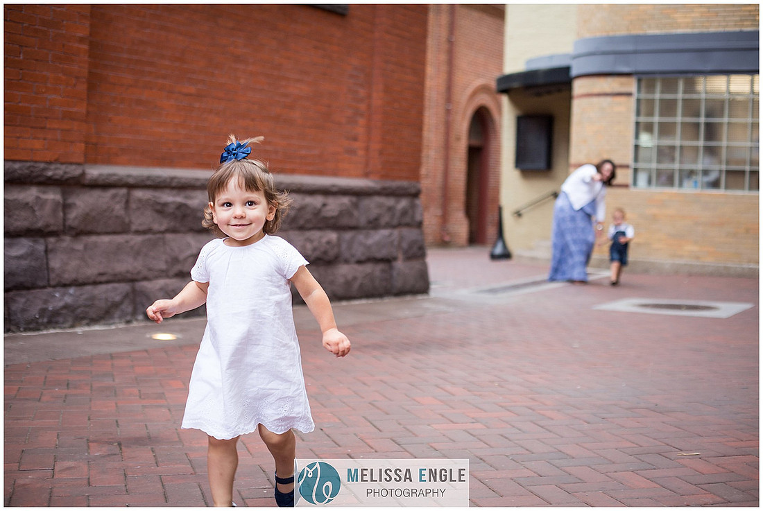 Candid family photo of parents with twins in downtown Lancaster City, PA.