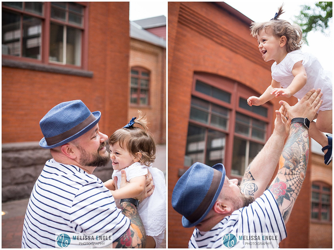candid photo of a father throwing his two-year-old daughter up in the air in downtown Lancaster City, PA by Melissa Engle Photography.