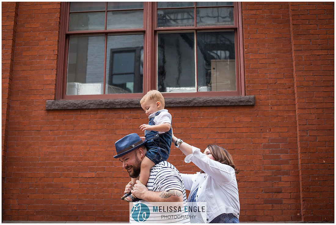 Candid family photo of parents with twins in downtown Lancaster City, PA.