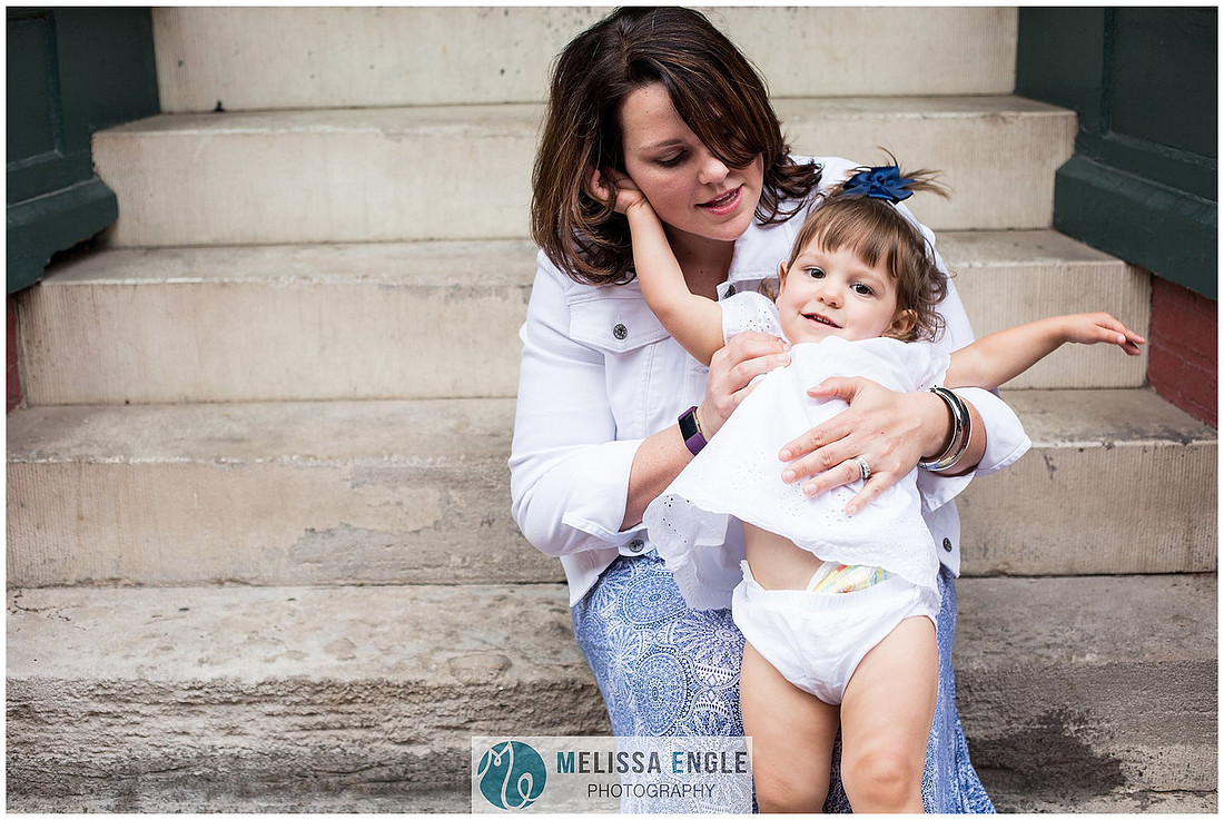 Candid family photo of parents with twins in downtown Lancaster City, PA.