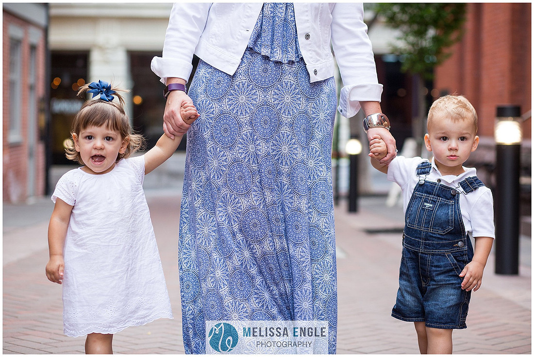 Candid family photo of parents with twins in downtown Lancaster City, PA.