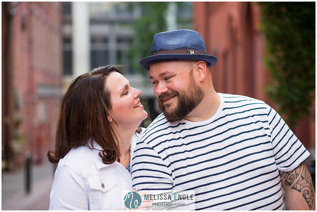 Candid family photo of parents with twins in downtown Lancaster City, PA.