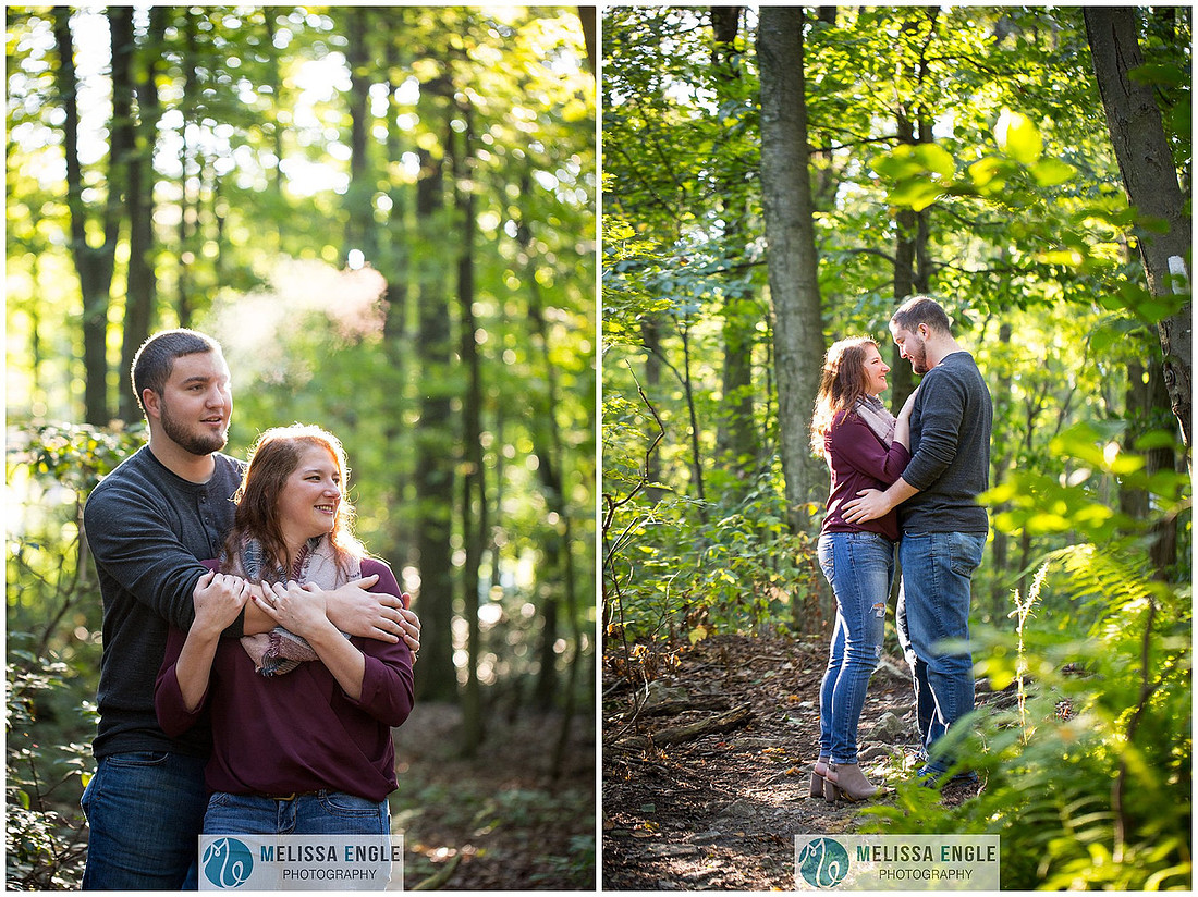 Engagement photo of a couple in the middle of the woods surrounded by trees, rocks and sunlight at Money Rocks County Park.