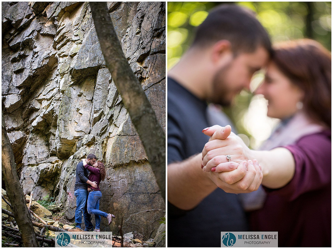Engagement photo of a couple in the middle of the woods surrounded by trees, rocks and sunlight at Money Rocks County Park.