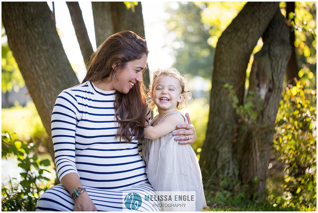Candid photo of a mother and daughter laughing in the sunlight in Lititz, PA.