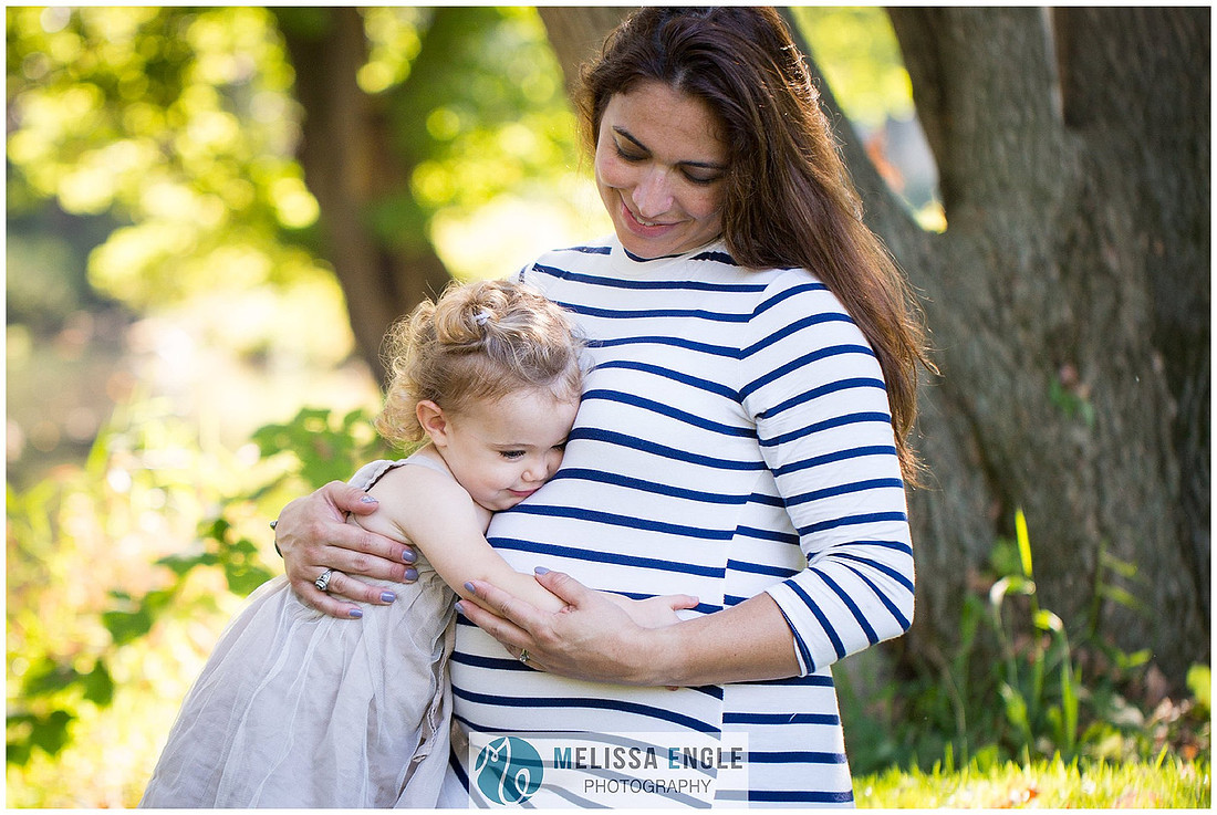Beautiful photo of a little girl hugging her mother's pregnant belly in Lititz, PA by Melissa Engle Photography.