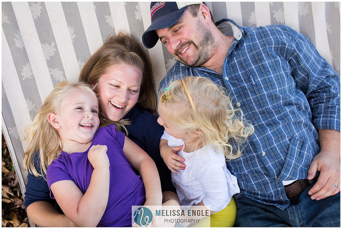 Photo of a happy family of four laughing and lying in a hammock in Lancaster, PA.